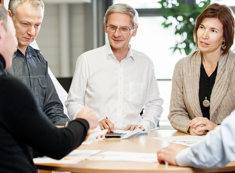 Diener Precision Pumps: Group picture of DDP engineers talking about customized pump solutions for medical technology, food or fuel.
